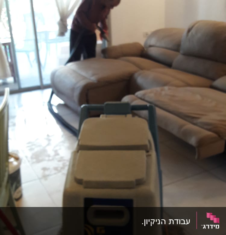 מכונת ניקוי שטיחים ואדם מנקה ספה